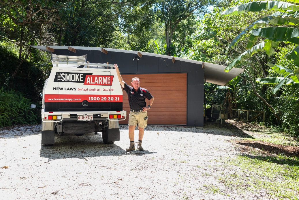 professional-smoke-alarm-technician-standing-with-service-ute