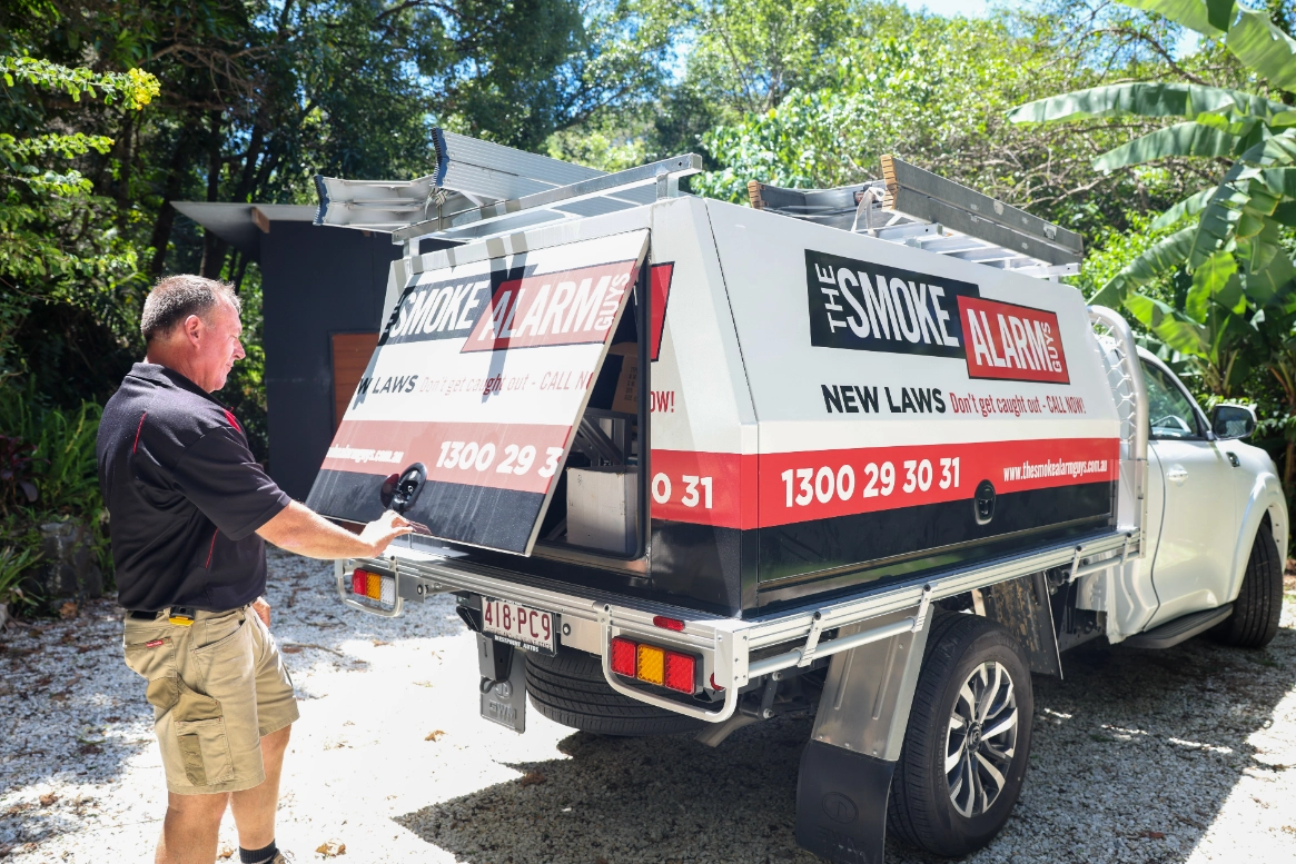 technician-opening-service-vehicle-canopy-the-smoke-alarm-guys